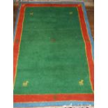 A green ground Gabbeh rug, decorated with stylised animals, within yellow, red and blue border,