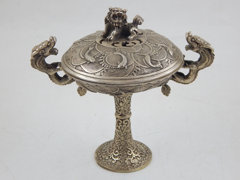 A Chinese white metal lidded incense burner, the knop in the form of a dog of fo on a ground of