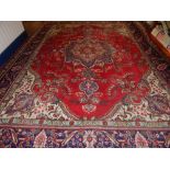 A red ground Isfahan rug, decorated with tear drop star medallion to centre, within floral