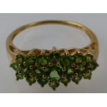 A peridot cluster ring, multi-claw set in a 9ct gold band.