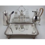 An early 20th century silverplated six bottle cruet, a rectangular tray with gadrooned border,
