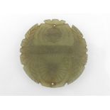 A Chinese green hard stone circular pendant, decorated with engraved foliate design. D.5cm