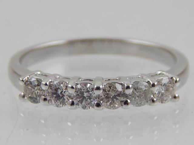 A diamond six stone dress ring, claw set in white metal stamped 750, 2.6g.