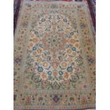 A cream Isfahan Kirk wool rug, decorated with scrolling foliage within pale green borders,