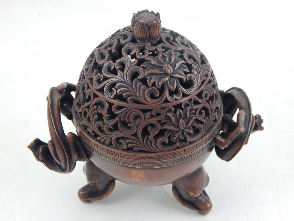 A Chinese bronze incense burner, the cover with pierced floral decoration, having twin dragon