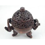 A Chinese bronze incense burner, the cover with pierced floral decoration, having twin dragon