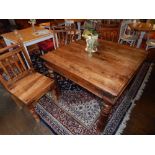A Continental square oak table, raised on turned legs, together with three matching chairs.