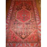 A red ground Shiraz rug, the centre with stepped tear drop medallion on a geometric ground, within