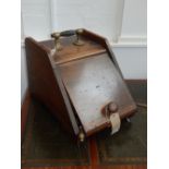 An Edwardian oak coal scuttle, with an ebonised and brass mounted handle, together with pair of