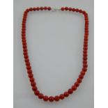 A uniform red beaded necklace.