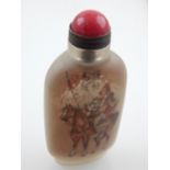 A Chinese reverse painted glass snuff bottle, decorated with a warrior in armour on a horse, with