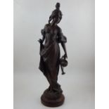 A late 19th century spelter figure of a writer, standing in a Classical pose, raised on a circular