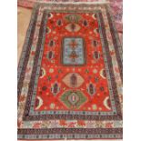 A red ground Caucasian carpet, overall with geometric and stylised, fringed. 220 x 130cm