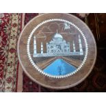 A circular Indian hardwood occasional table, the top decorated with a view of the Taj Mahal.