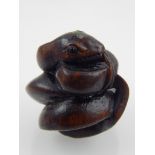 A Japanese hardwood netsuke modelled as a coiled snake, bears signature disc. H. 3cm