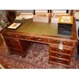 A George III style mahogany pedestal desk, with leather inset top over nine drawers and slides. W.