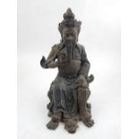 A Chinese cast bronze figure of a warrior seated on a stool. H. 21cm