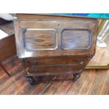 A 17th century style oak bureau, the panelled fall enclosing a fitted interior above two drawers, on