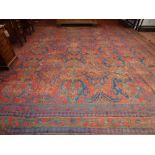 A red ground Ushak carpet, decorated with geometric design, fringed, 648 x 480cm