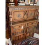 A 20th century Jacobean design oak Duodarn or court cupboard, enclosed by four carved panelled doors