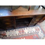 A 20th century oak desk, the rectangular top above an arrangement of seven drawers, on short