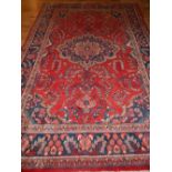 A red ground North West Persian carpet, decorated with stylised floral design, fringed,