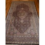 A pink and indigo Tabriz rug, decorated with stylised floral design,