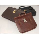 A black leather briefcase, together with two further brown leather cases,