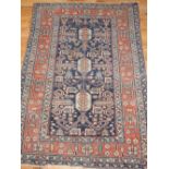 A Caucasian rug, the stylized floral design on a blue ground within a multi-panel border,