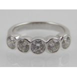 An 18ct white gold and five stone rubover diamond ring.