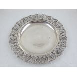 A 20th white metal dish, probably Egyptian, circular with a with a pierced palmette border,