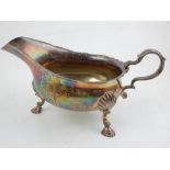 A silver sauce boat, Birmingham 1947, by Thomas Ducrow & Sons, raised on three shell and hoof feet,