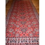A red ground Suzani carpet, decorated with floral medallions to centre, fringed,
