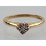 A 9ct yellow gold and illusion set diamond solitaire ring, stamped 375 to shank.