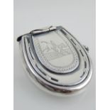 A silver plated vesta case, fashioned as a lucky horse shoe.