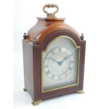 A early 20th century mahogany bracket type mantel clock, the silvered foliate engraved chapter