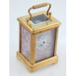 A miniature brass case carriage clock, with porcelain panels.