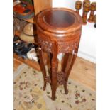 A carved hardwood jardiniere stand, the circular top above pierced panels and carved legs joined