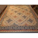 A cream ground Turkish kelim carpet, decorated with geometric medallions to centre within pale