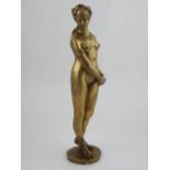 A 20th century bronze figure of an odalisque, standing with hands crossed to one side and looking to