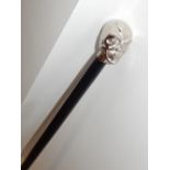 A silver plated skull handled walking cane.