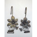 A pair of white metal curtain tie-backs, modelled with fruit and flowers, (2)