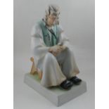 A large Zsolnay porcelain model of a seated elderly shoemaker. H. 33cm