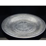 A Persian white metal salver, engraved with script and foliate design, Diam. 28cm