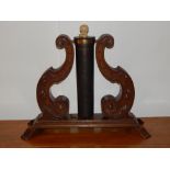 An early 20th century cylindrical dinner gong and striker supported by two carved oak lyre