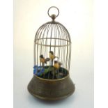 A Victorian style clockwork singing bird automaton in gilt metal birdcage with embossed floral