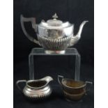 A George V demi fluted silver sugar bowl together with a similar silver plated teapot and cream jug