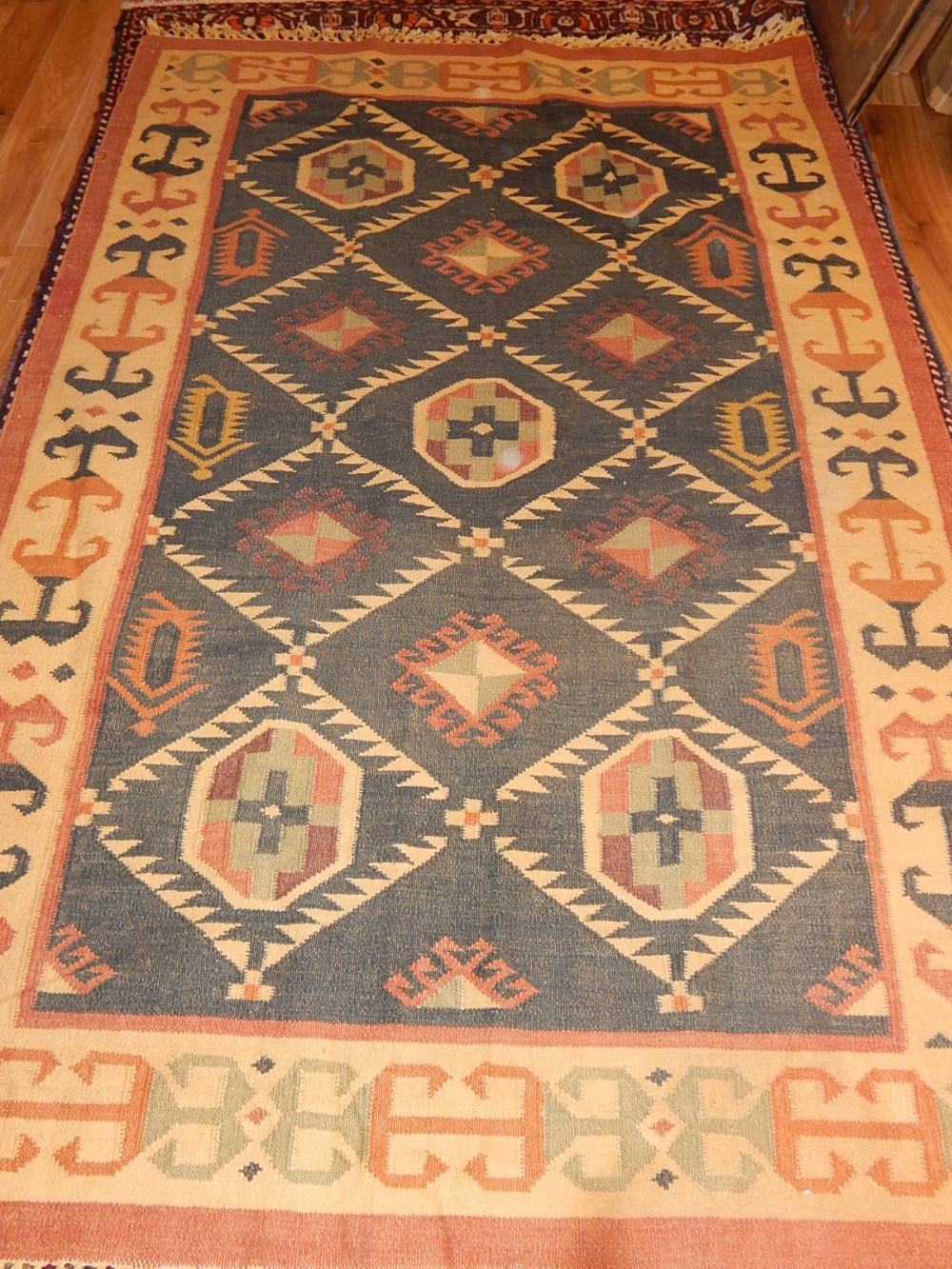 An olive ground Turkish kelim rug, decorated with geometric stepped and greek key bordered