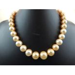 A golden pearl graduated necklace, comprising thirty-five large pearls, with a yellow metal and