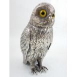 A Continental white metal desk piece modelled in the form of an owl, with detailed plumage and amber